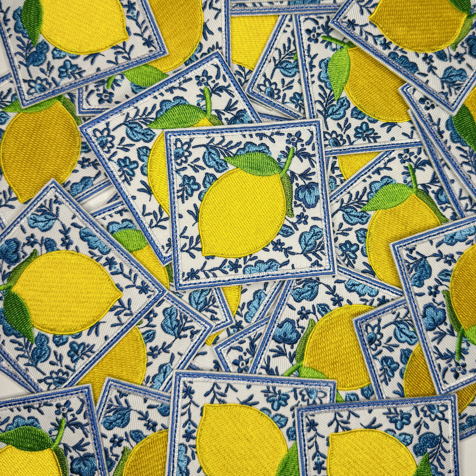 Pattern of yellow lemons on a blue and white geometric background