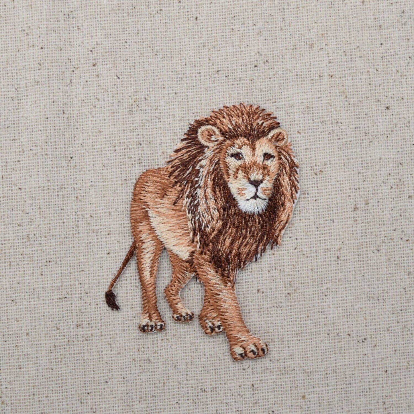 Embroidered lion on a textured fabric background