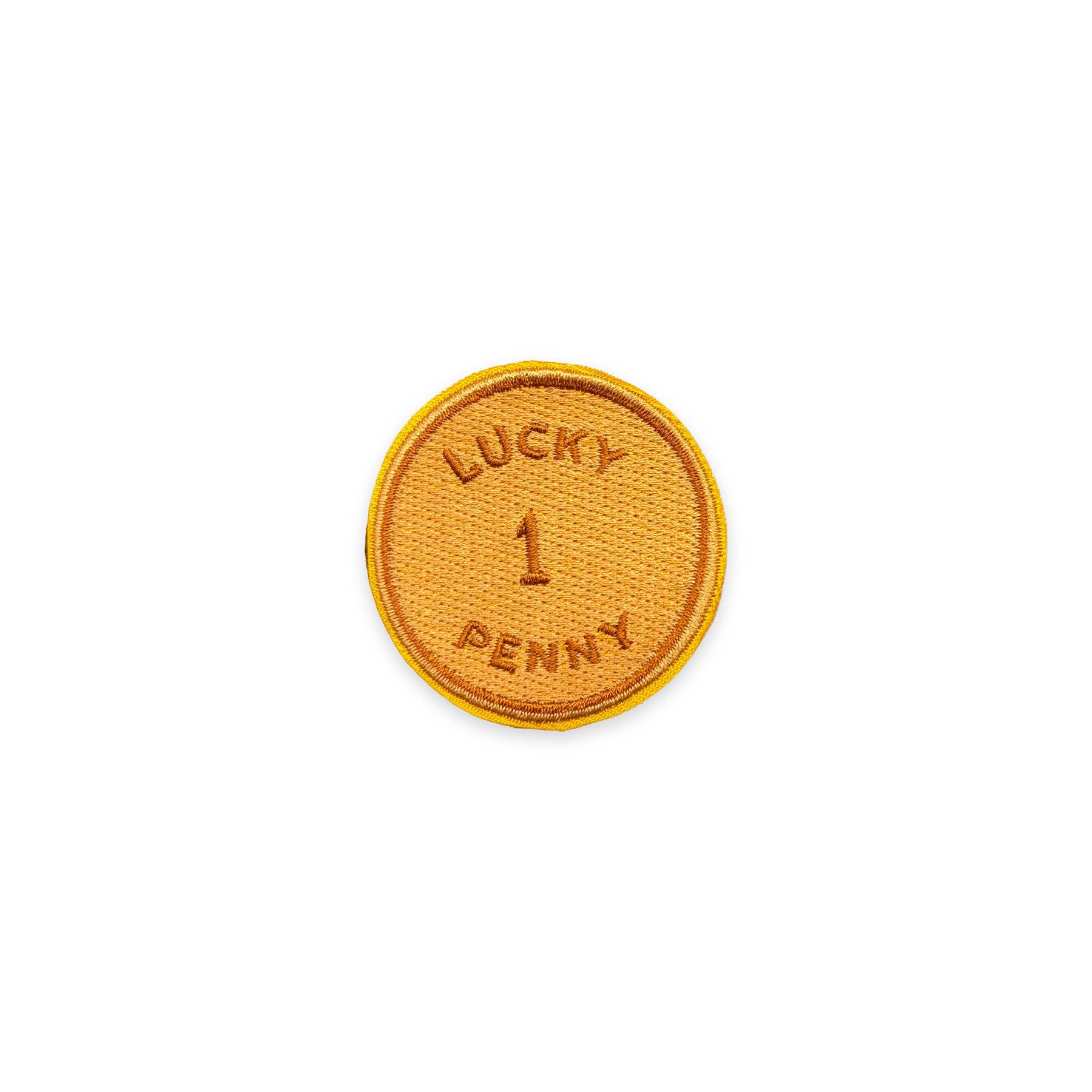 A circular embroidered patch with a golden-yellow border and a textured orange-brown center, featuring the text 'LUCKY 1 PENNY' embroidered in matching thread on a plain white background.