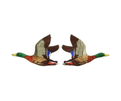 Two embroidered duck patches on a beige fabric background