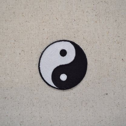 Yin and yang symbol on a textured beige background