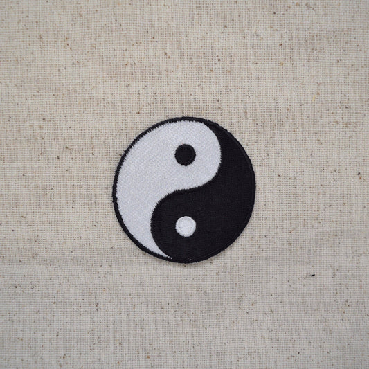 Yin and yang symbol on a textured beige background