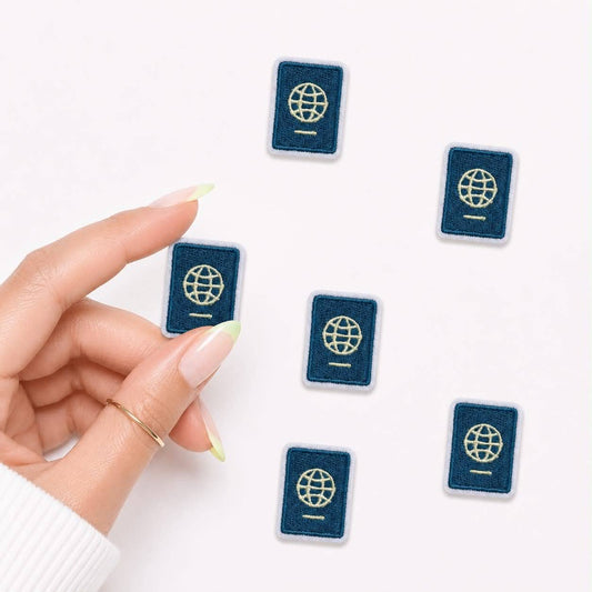 Hand holding a small blue passport-shaped object with a white background