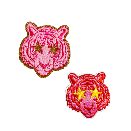 Two pink tiger patches with yellow stars on a white background
