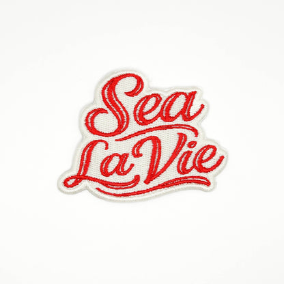 Red 'Sea La Vie' text on a white background