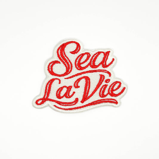 Red 'Sea La Vie' text on a white background