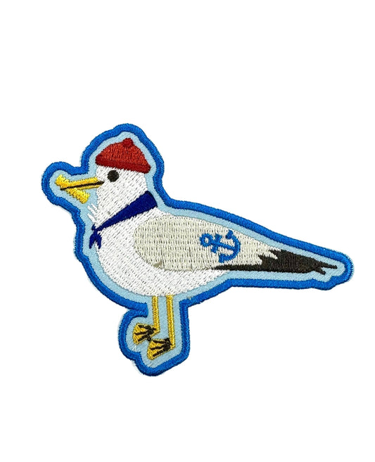 Embroidered patch of a bird with a red cap on a white background