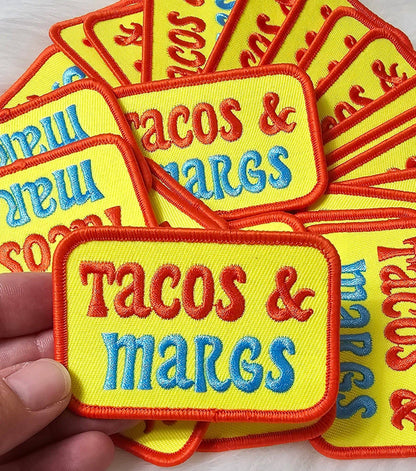 Embroidered patches with 'Tacos & Marges' text on a yellow background.