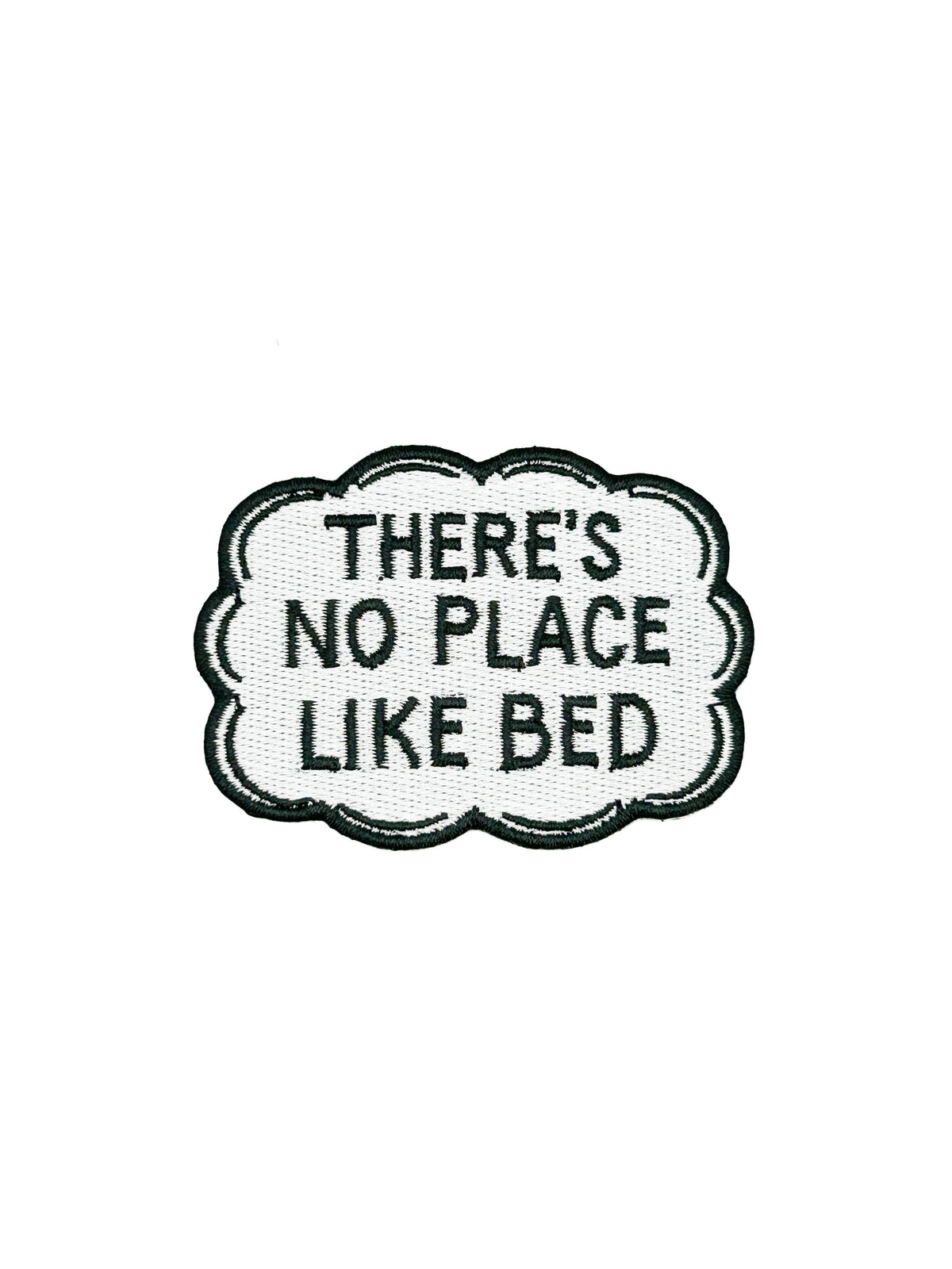 Embroidered patch with text 'THERE'S NO PLACE LIKE BED' on a white background