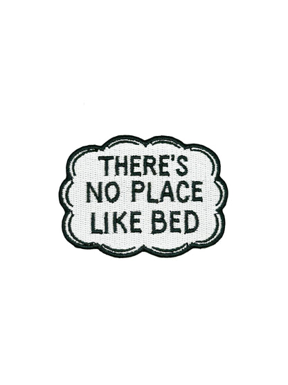 Embroidered patch with text 'THERE'S NO PLACE LIKE BED' on a white background