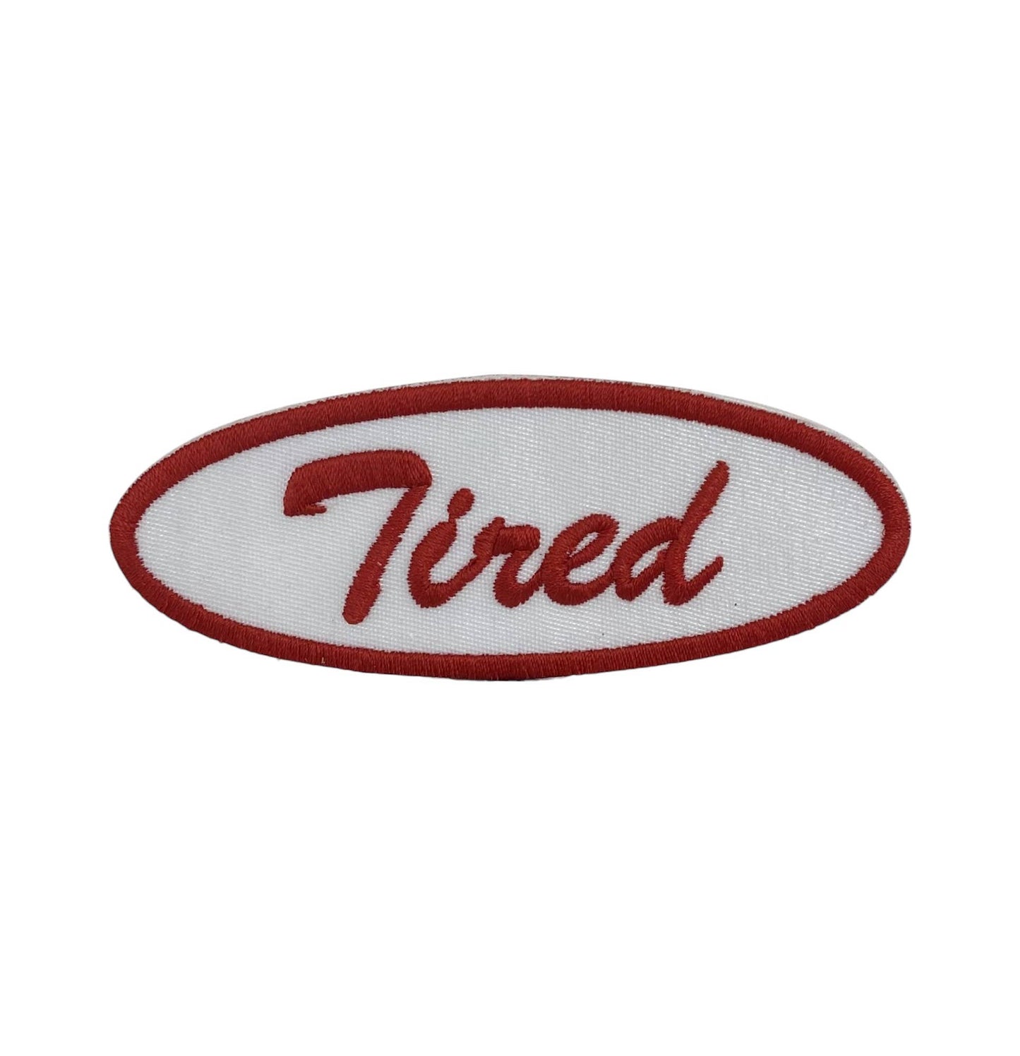 Embroidered patch with 'Tired' text on a white background