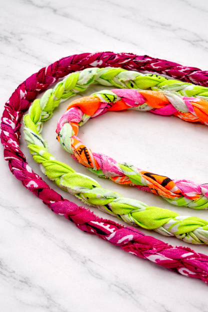Colorful braided bandana necklaces on a marble surface