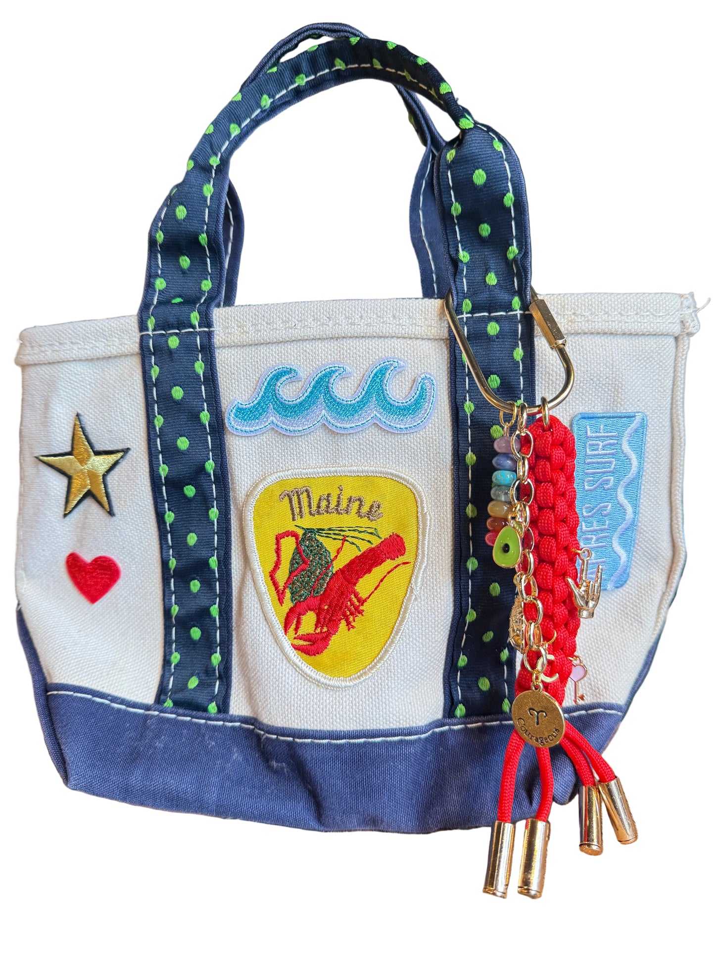 Handbag with decorative elements and a keychain on a wooden surface