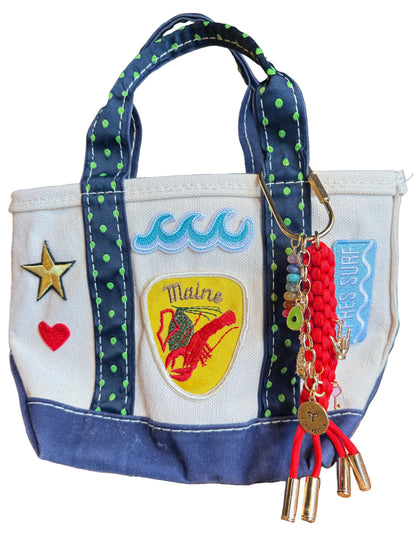 Handbag with decorative elements and a keychain on a wooden surface