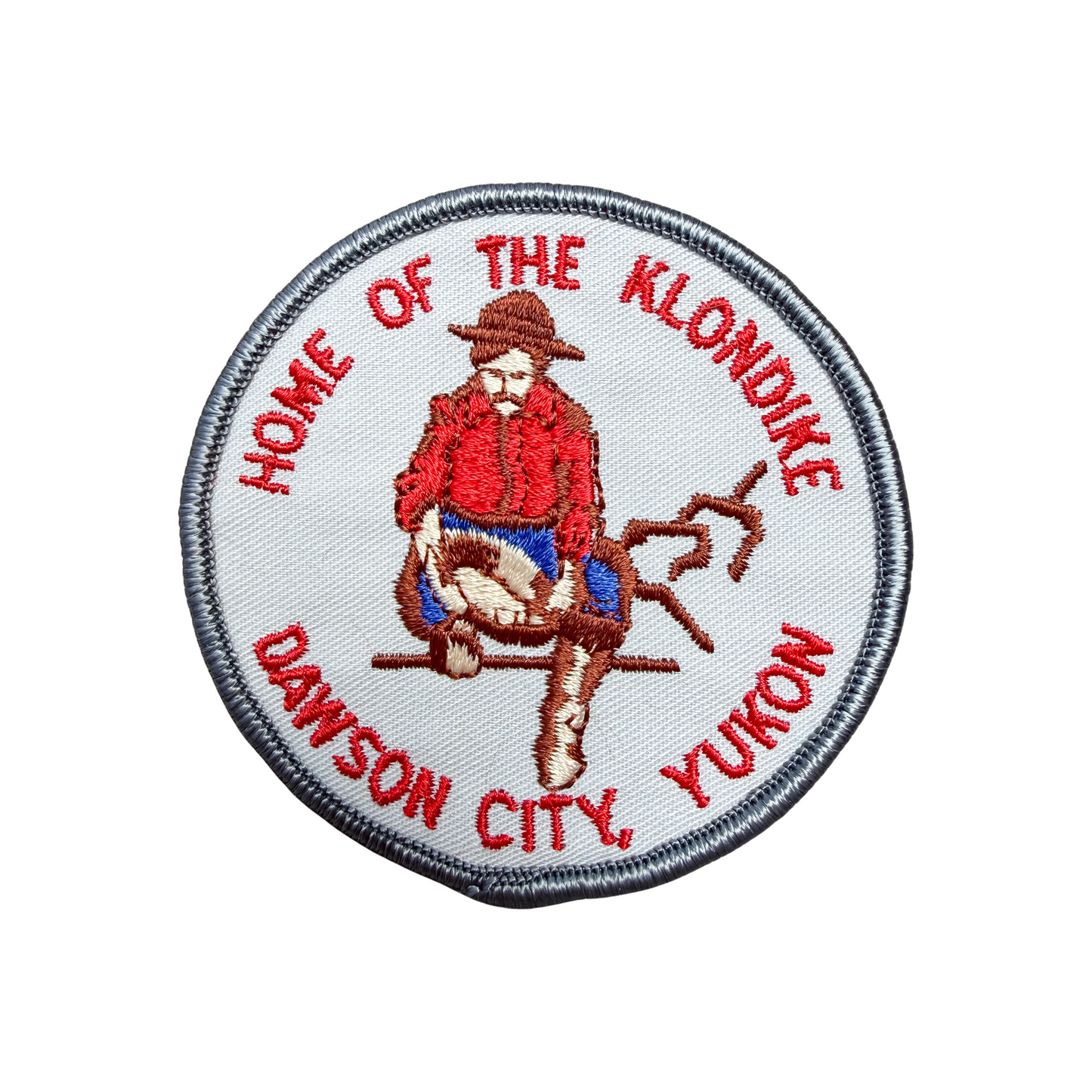 Patch with a Klondike-themed design featuring a person in a red coat and hat, text 'Home of the Klondike' and 'Dawson City, Yukon'.