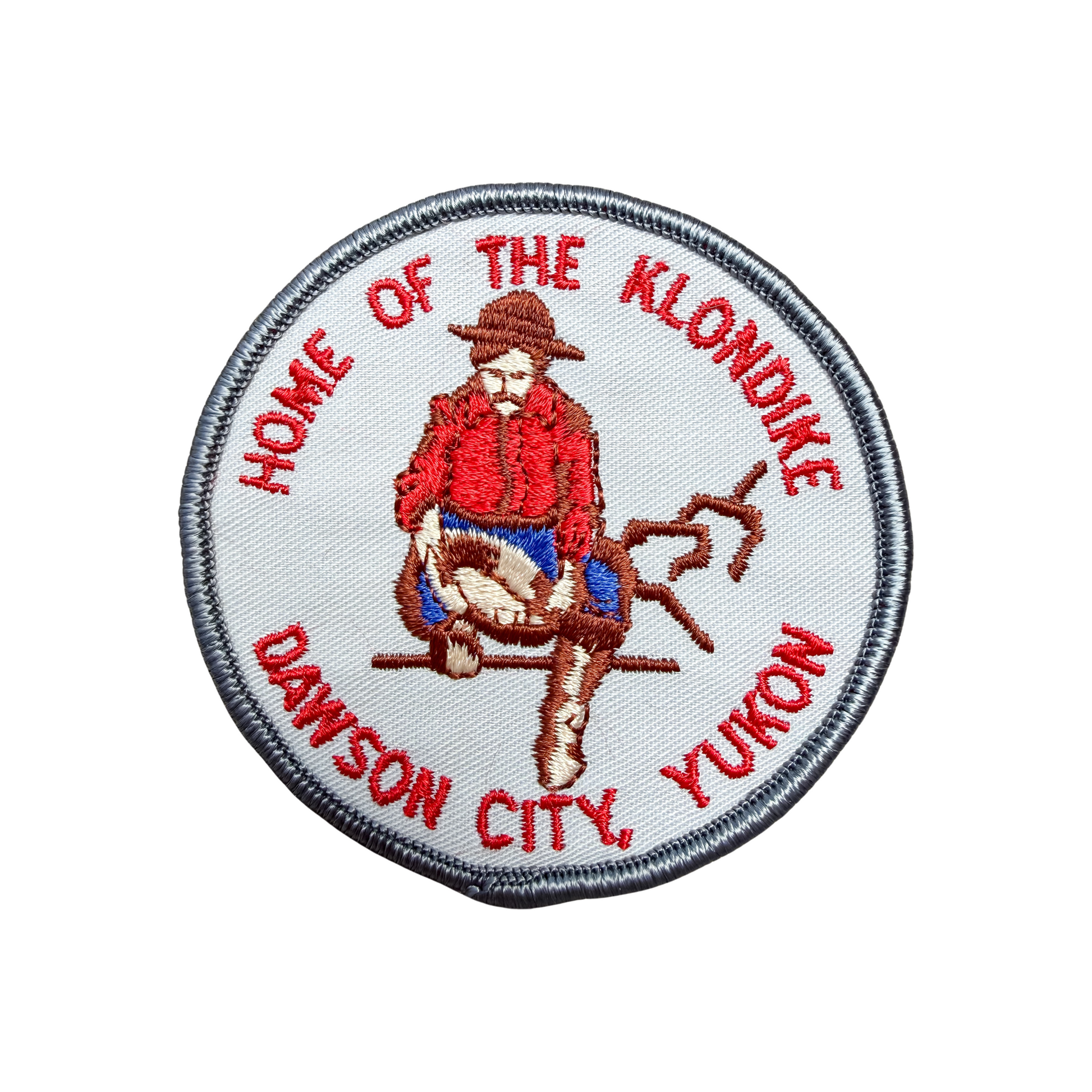 Patch with a Klondike-themed design featuring a person in a red coat and hat, text 'Home of the Klondike' and 'Dawson City, Yukon'.