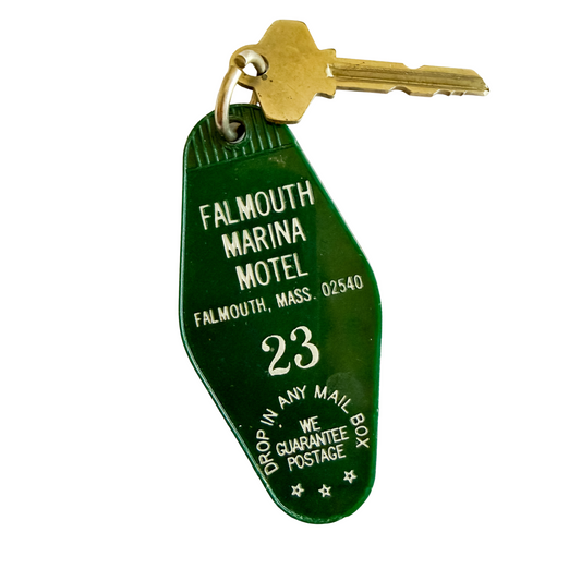 Green motel keychain with 'Falmouth Marina Motel' text and a key attached, on a white background.