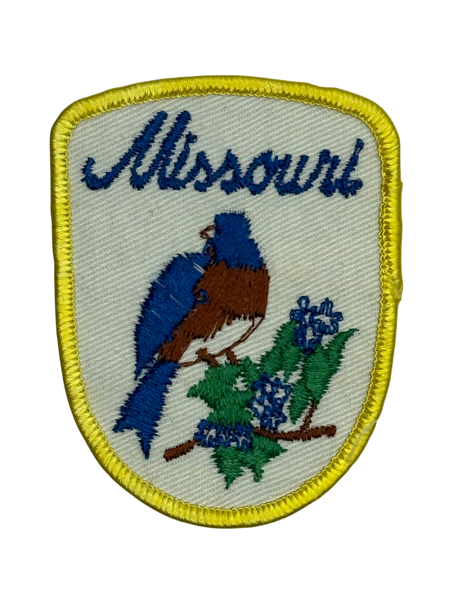 Embroidered patch with a blue bird and flowers, featuring the word 'Missouri'.