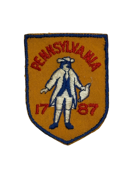Embroidered patch with 'Pennsylvania 1787' text and a historical figure on an orange background.