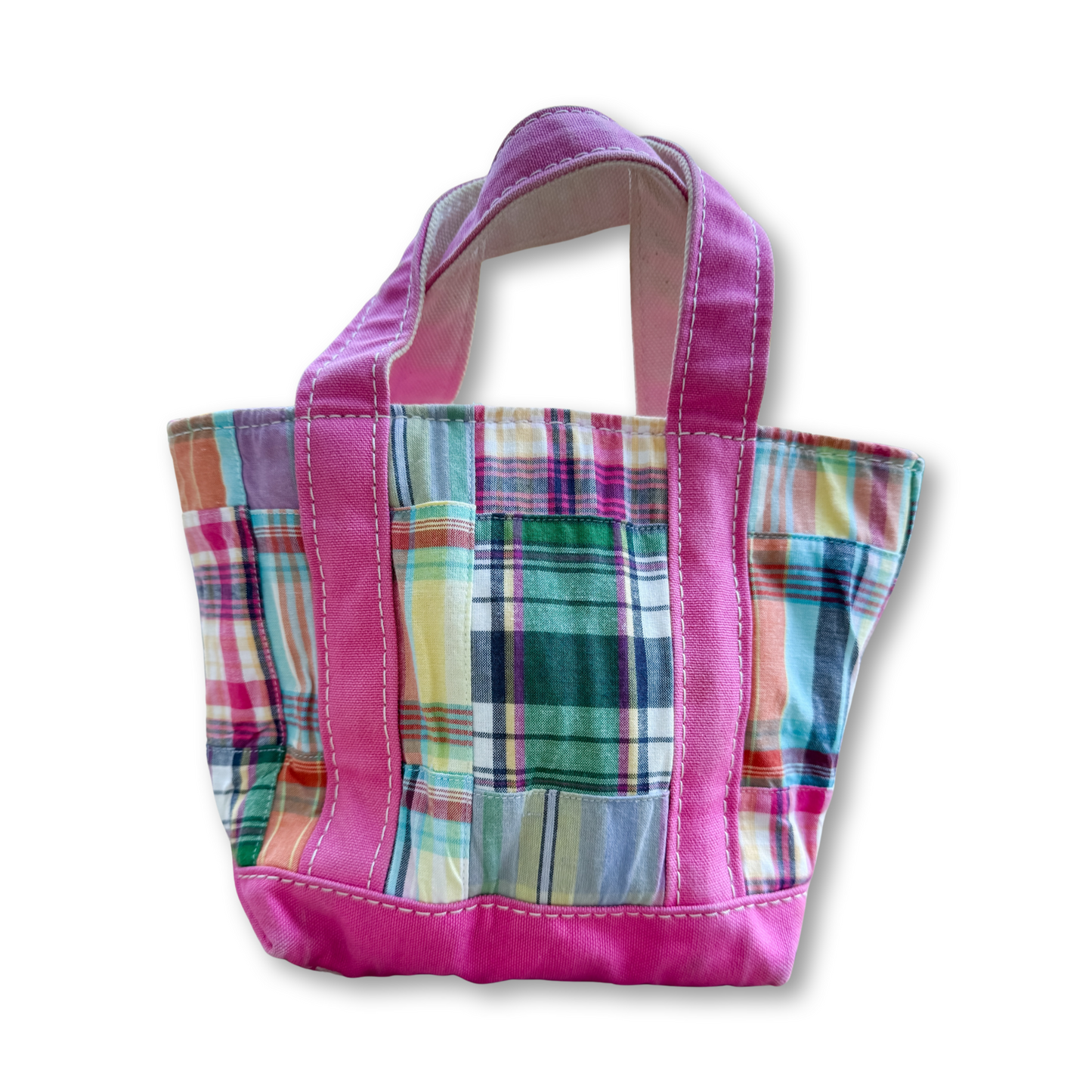 A small fabric tote bag with a multicolor plaid pattern and bright pink handles and bottom trim, shown on a plain white background.