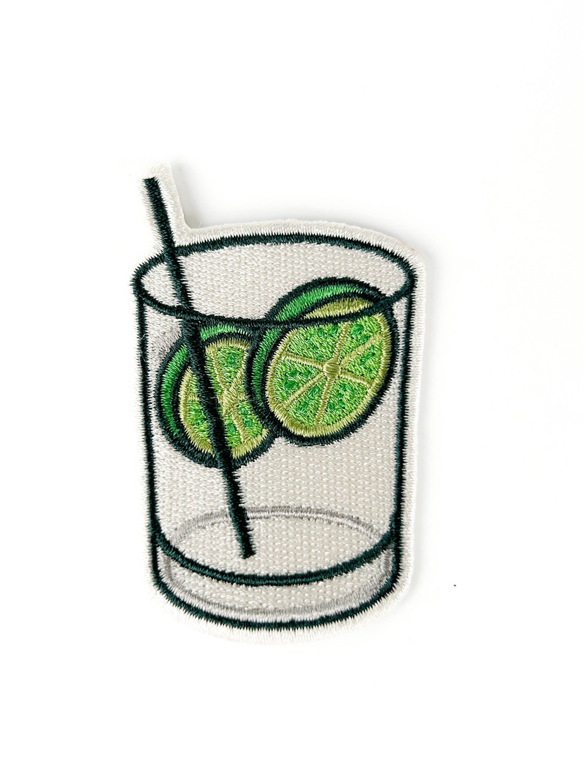 Embroidered patch of a glass with lime slices and a straw on a white background