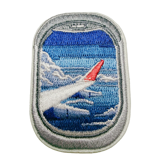 Embroidered patch of an airplane window view on a plain background
