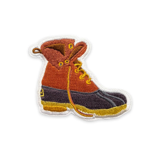 Embroidered patch of orange and gray bootson a white background