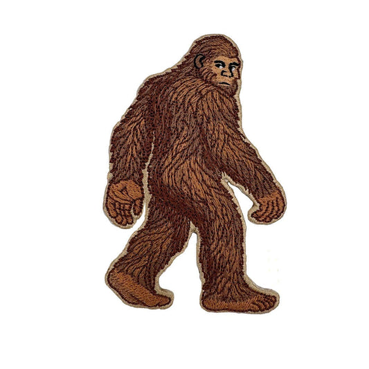 Embroidered patch of a brown Bigfoot figure on a white background