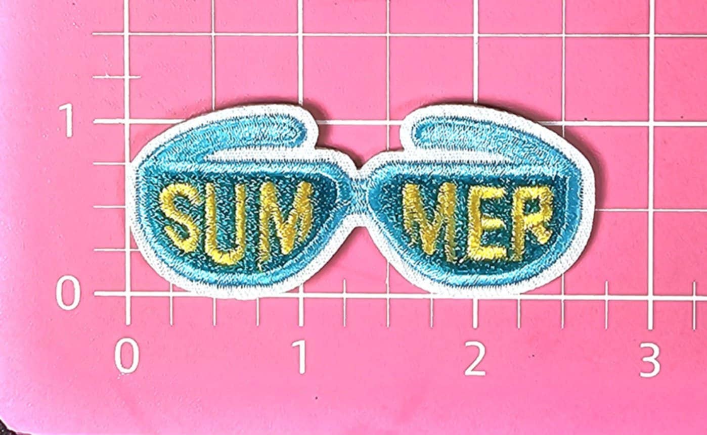 Embroidered patch with sunglasses design and 'SUMMER' text on a pink grid background