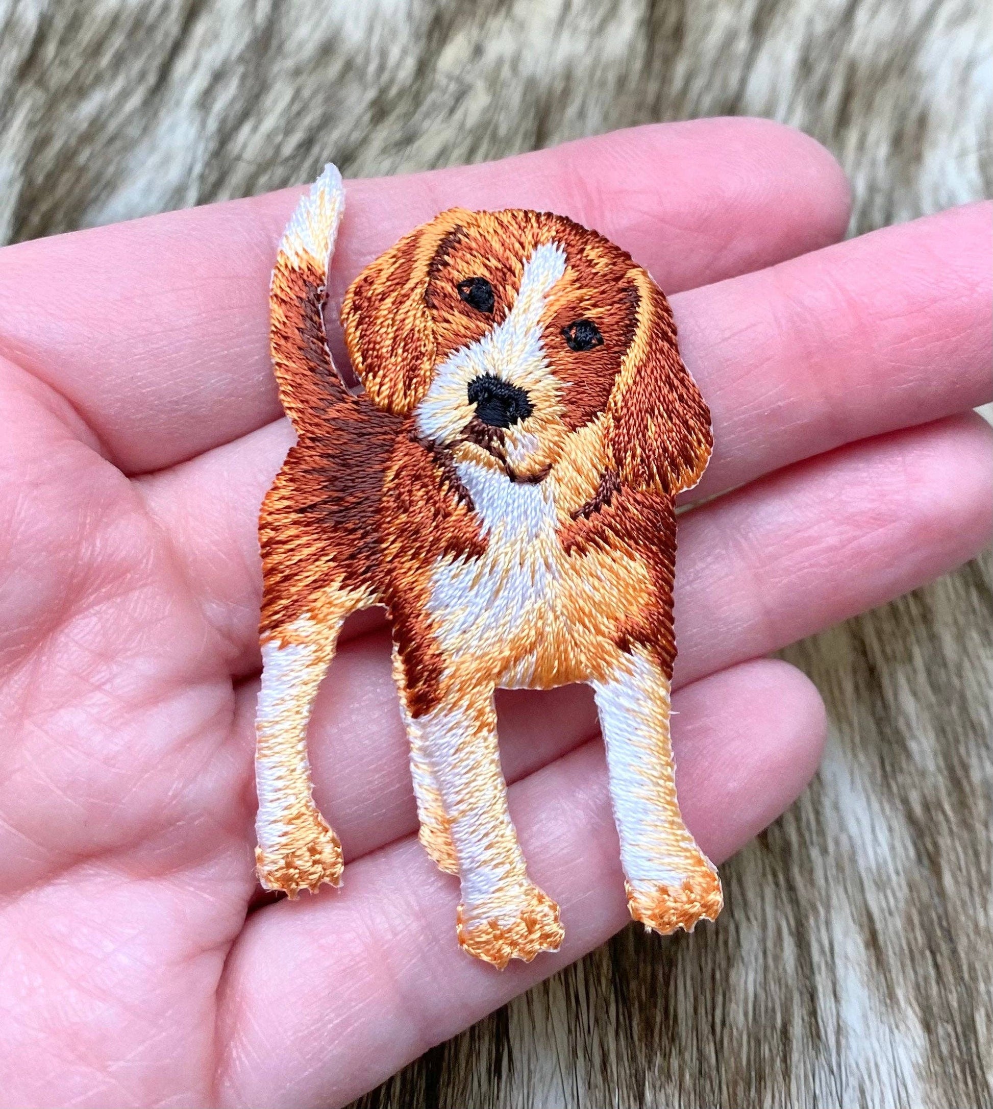 Embroidered dog patch held in a hand