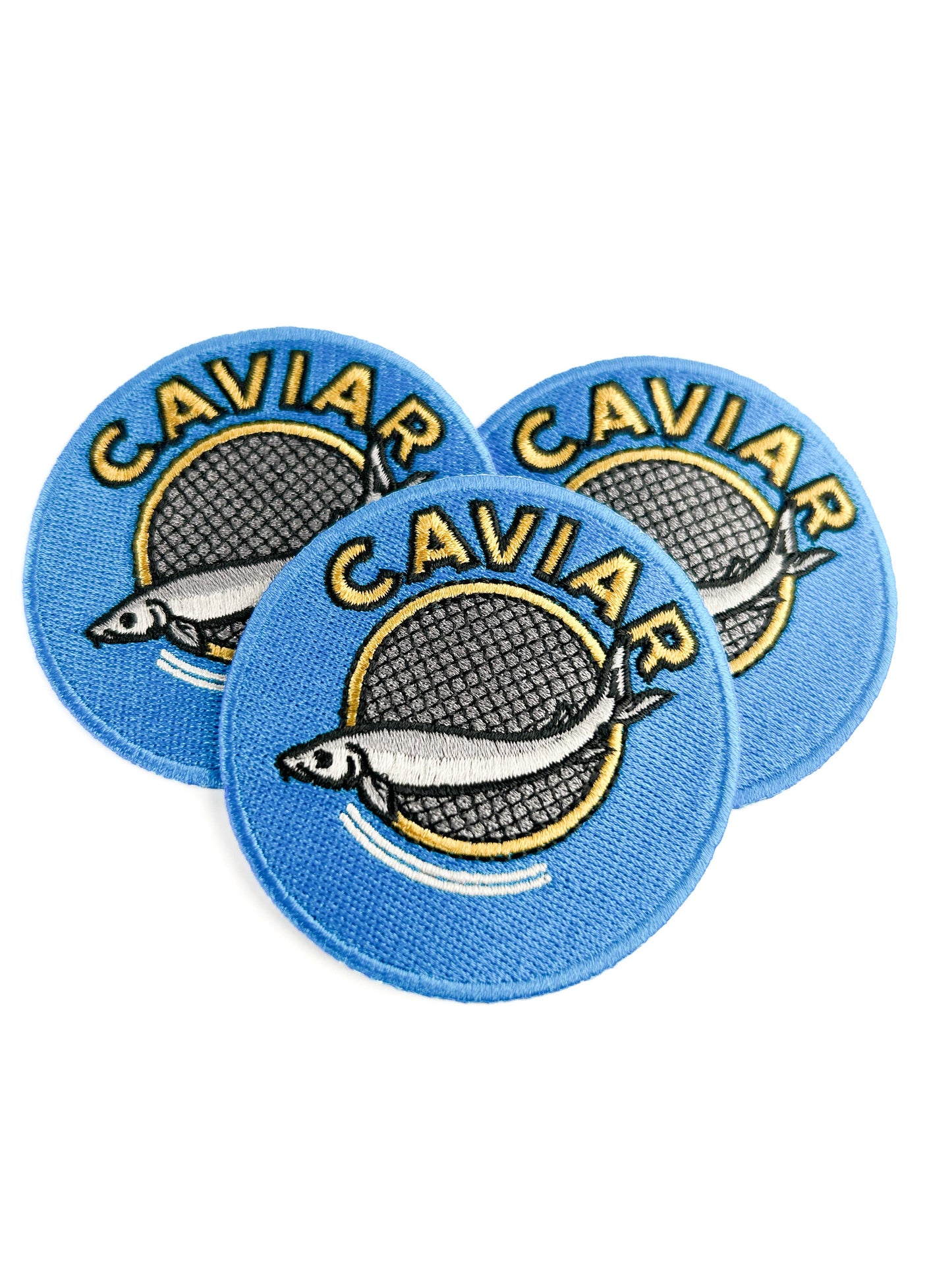 Three round blue patches with 'CAVIAR' text and fish illustration on a white background