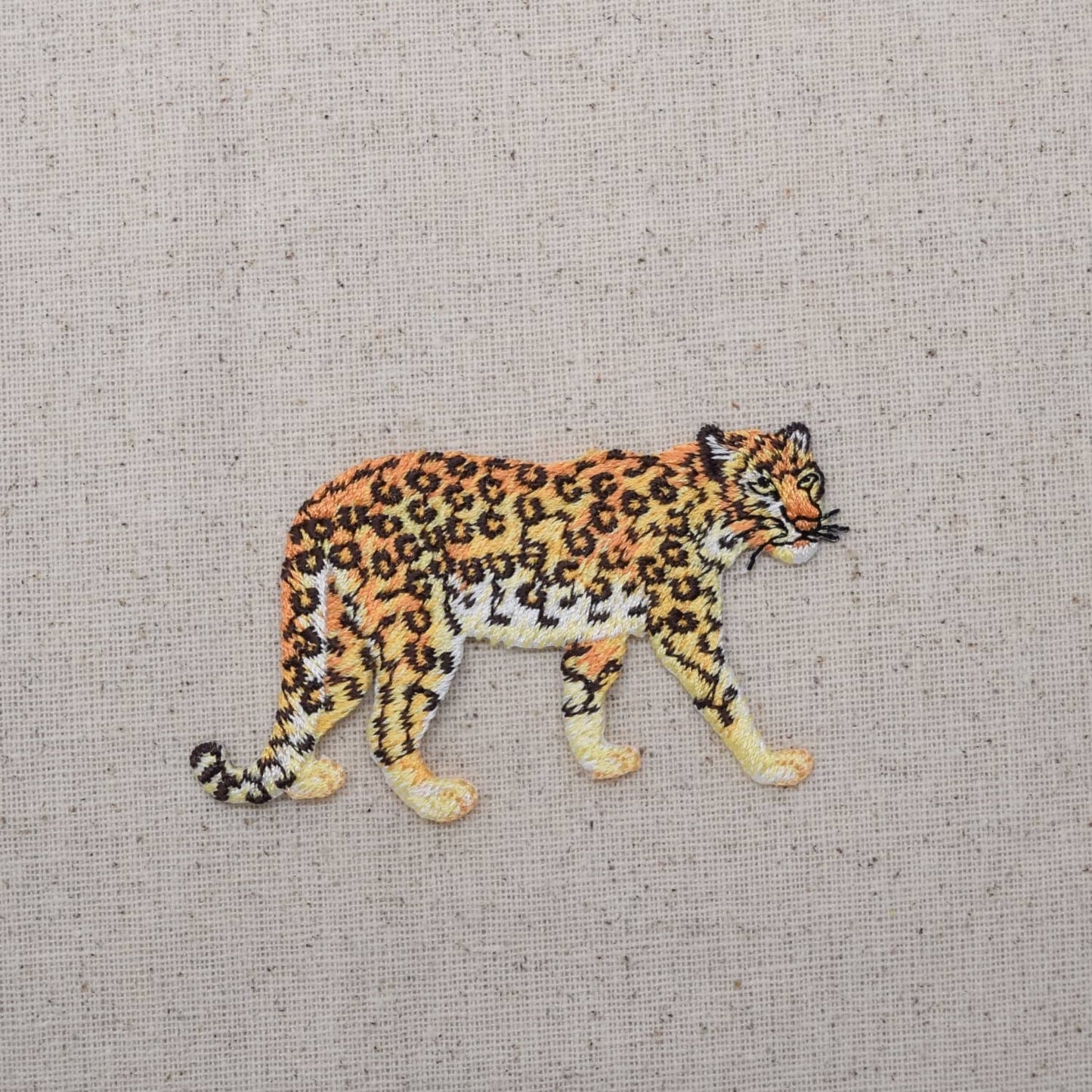 Embroidered patch of a leopard on a textured fabric background