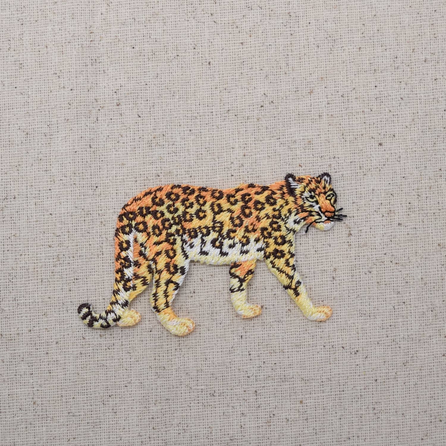 Embroidered patch of a leopard on a textured fabric background