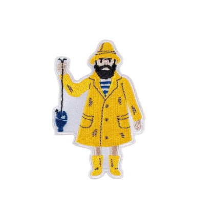 Sticker of a fisherman wearing a yellow raincoat and boots holding a fishing line with a blue fish attached on a beige background