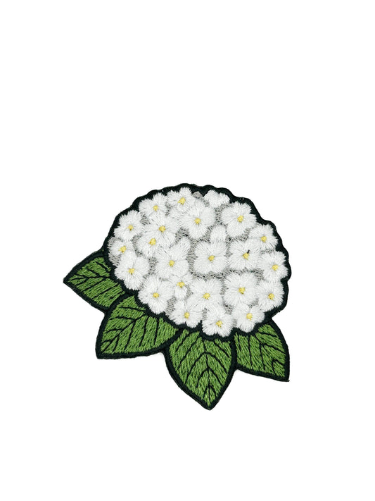 Embroidered patch of a white hydrangea and green leaves on a white background