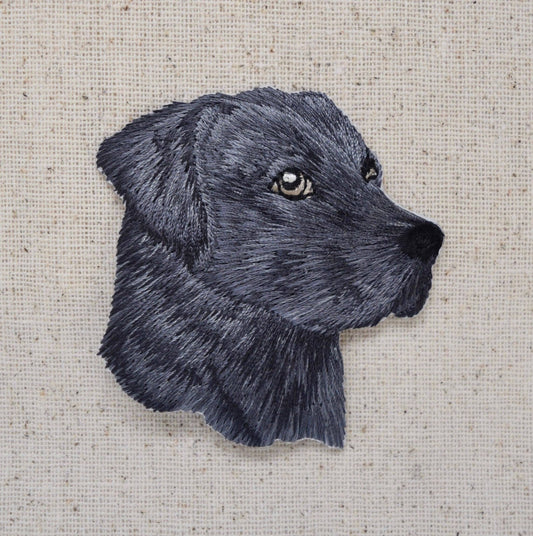Embroidered black dog's head on a textured beige background