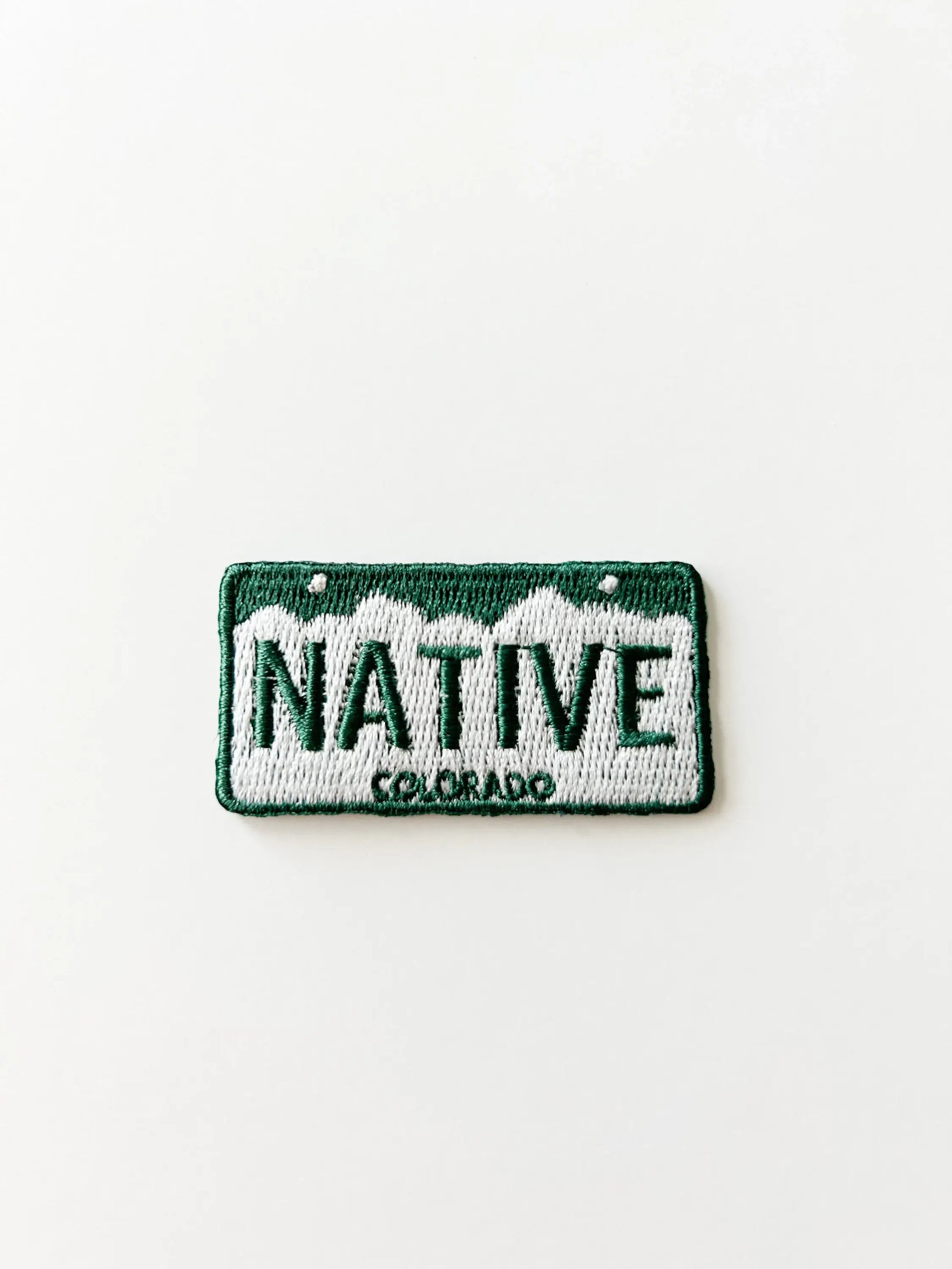 Embroidered patch license plate design with 'NATIVE COLORADO' text on a white background