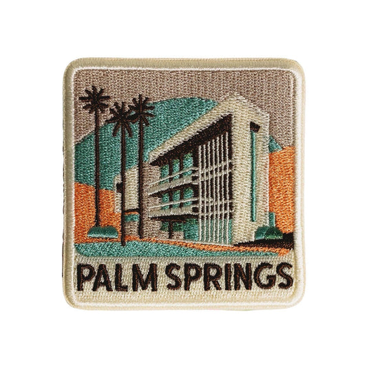 Embroidered patch with a building, palm trees, and 'Palm Springs' text on a beige border.
