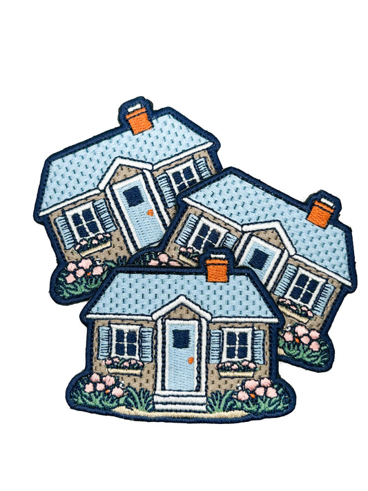Three embroidered house patches on a white background