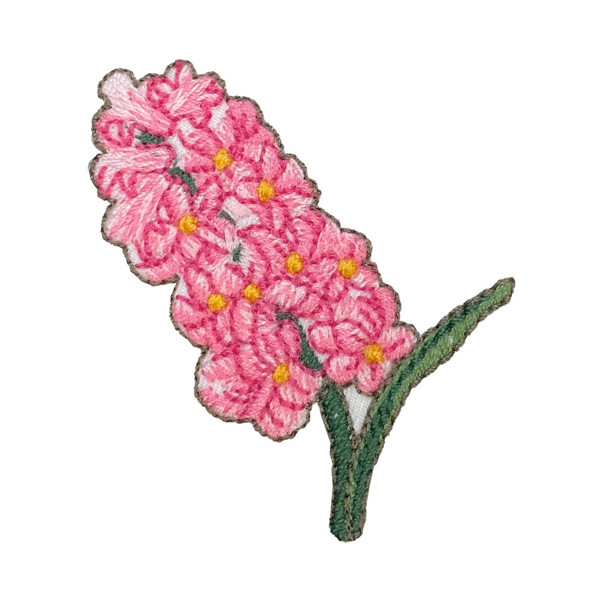 Embroidered pink hyacinths with green leaves and stem on a white background