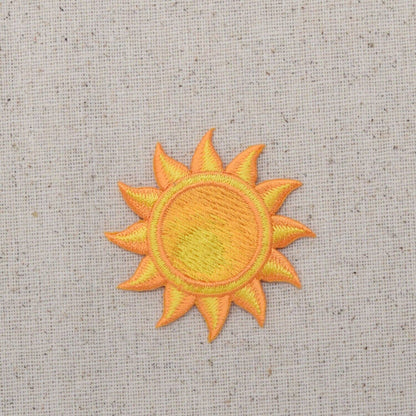 Embroidered sun patch on a textured fabric background