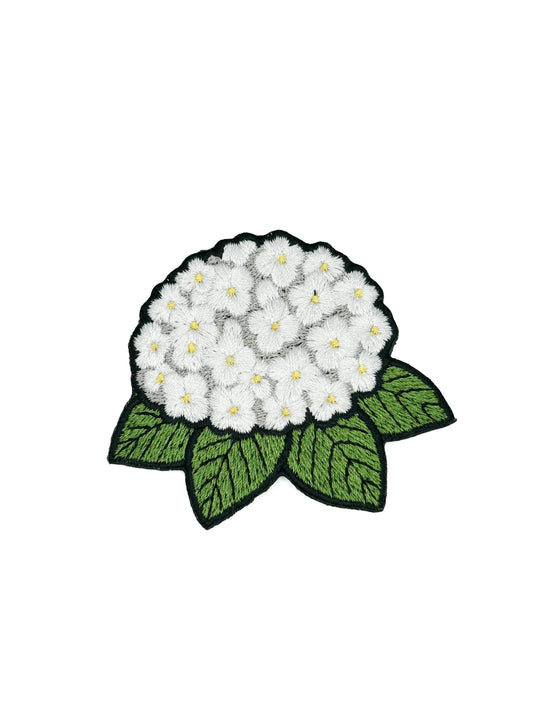 Embroidered patch of a white hydrangea and green leaves on a white background