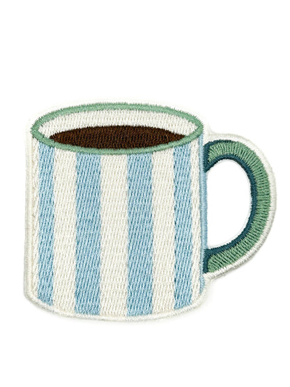 An embroidered patch of a striped coffee mug with vertical light blue and white stripes, a dark brown interior, and a green handle and rim, shown on a plain white background.
