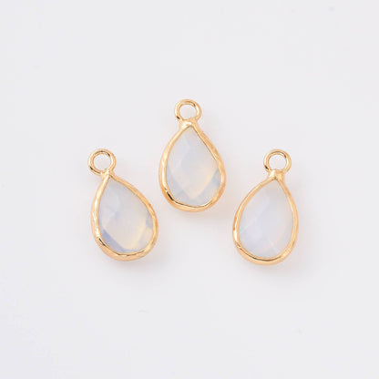 Three teardrop-shaped opalite gemstones with gold settings on a white background