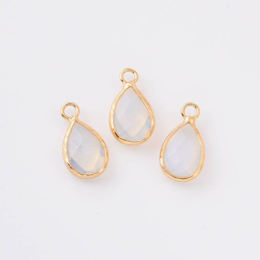 Three teardrop-shaped opalite gemstones with gold settings on a white background