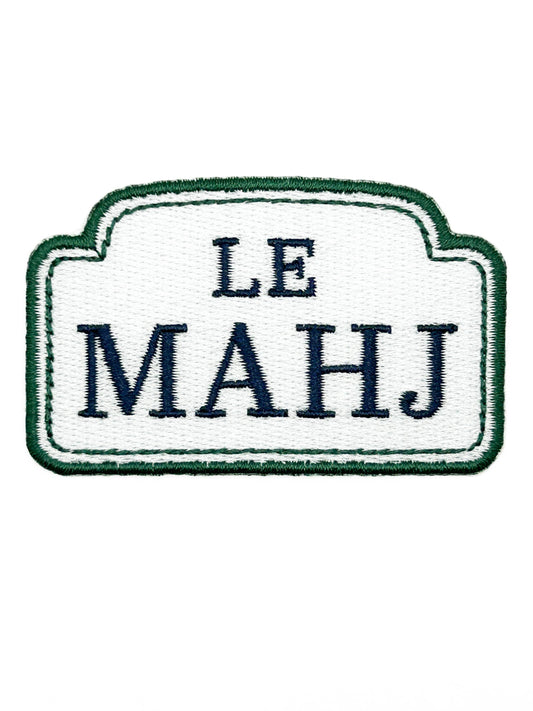 An embroidered patch with a white center, dark green border, and navy blue text reading 'LE MAHJ' on a plain white background.